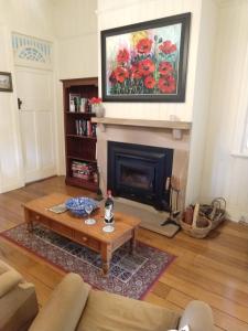 a living room with a coffee table and a fireplace at Amiens Cottage. Queenslander, charming, central. in Stanthorpe