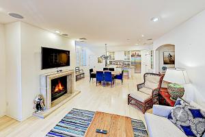 a living room with a fireplace and a dining room at Santa Barbara Luxe Villa in Santa Barbara