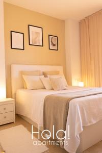 マニルバにあるHola! apartments at Coto Realのベッドルーム1室(大型ベッド1台、白いシーツ、枕付)