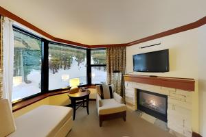 ein Wohnzimmer mit Kamin und Fernseher in der Unterkunft Resort at Squaw Creek's 521 in Olympic Valley