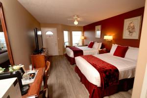 a hotel room with two beds and a television at Casa Grande Inn in Qualicum Beach