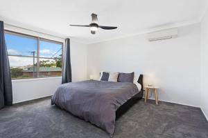 86 Becker Road في فورستر: غرفة نوم بها سرير ونافذة كبيرة