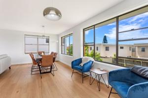 86 Becker Road في فورستر: غرفة معيشة مع أريكة زرقاء وطاولة وكراسي