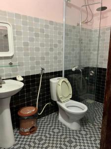 y baño con aseo, lavabo y ducha. en Ngan Nga Bac Ha Hotel en Bắc Hà