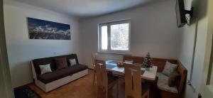 a small living room with a table and a couch at Apartma Dana-Brinjtesa in Jesenice