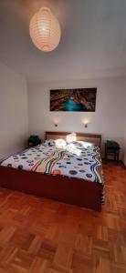 a bedroom with a bed with a painting on the wall at Apartma Dana-Brinjtesa in Jesenice