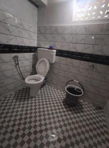 un bagno con servizi igienici e secchio di Stargaze Backpackers Hostel a Guwahati