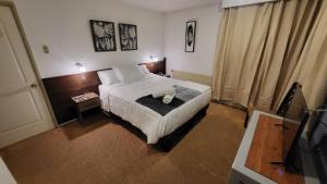 een slaapkamer met een bed met een teddybeer erop bij HOTEL BORDEPLAZA - ex Monterilla in Viña del Mar +31 foto's