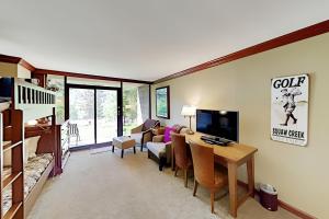 a living room with a desk and a living room with a couch and a tv at Resort at Squaw Creek's 126 in Olympic Valley