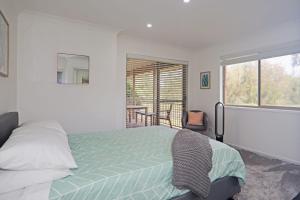 um quarto com uma cama e uma grande janela em Boomerang em Sussex inlet