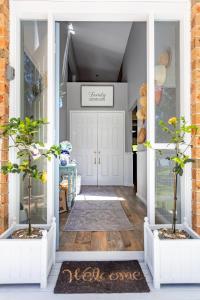 a front door of a house with two potted plants at Fair Views in Sussex inlet