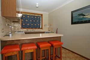 cocina con barra con taburetes de naranja en Perfect family holiday, en Berrara