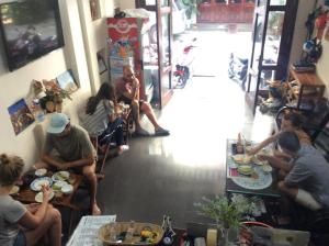 a group of people sitting at tables in a restaurant at Hồng Phát Hostel in Hue