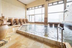 a large indoor pool in a hotel room with chairs at Auberge Amanohashidate in Miyazu