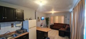 a kitchen with a refrigerator and a couch in a room at GATED AND SECURED APPARTMENT 6 MINS FROM THE BEACH in Puerto Peñasco