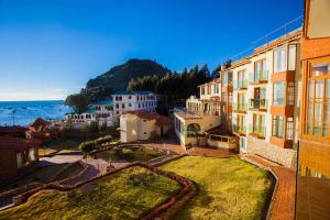 een groep gebouwen met de oceaan op de achtergrond bij Hotel Rosario Lago Titicaca in Copacabana