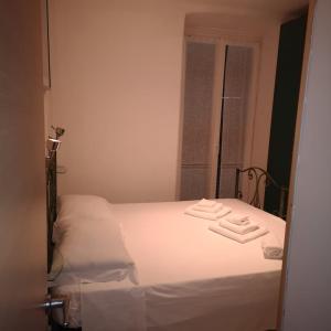 ラ・スペツィアにあるSTELLA MARINAのベッドルーム1室(白いベッド1台、タオル2枚付)