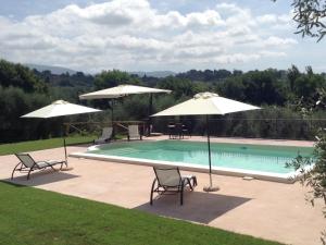 una piscina con due sedie e ombrelloni di Tranquil holiday home in Selci with swimming pool a Selci