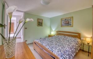 a bedroom with a bed and a vase with flowers on a table at 3 Bedroom Stunning Home In Ventimiglia in Ventimiglia