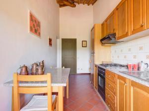 eine Küche mit Holzschränken und einer Arbeitsplatte in der Unterkunft Belvilla by OYO Orchidea Primo Piano in Peccioli