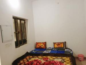 um quarto com uma cama com um cobertor em cima em Veera's Hostel em Pushkar mais 64 fotografias