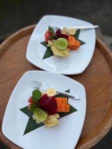two plates of food on a wooden table at Taman Ayu Ubud in Ubud