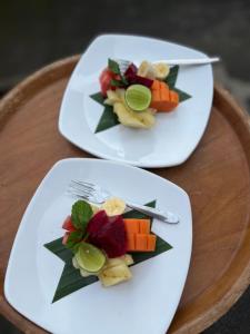 dos platos de comida en una mesa de madera en Taman Ayu Ubud en Ubud