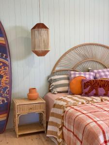 a bedroom with a bed and a table and a lamp at The Pink Lodge in Lorne