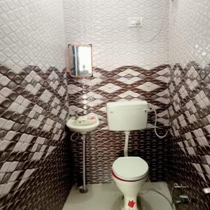 Veera's Hostel في بوشكار: حمام مع مرحاض ومغسلة
