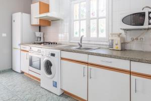 a white kitchen with a washer and dryer in it at Calpe Chalet a 5 min de la playa in Calpe