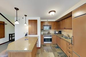 a kitchen with wooden cabinets and a counter top at Resort at Squaw Creek's 810 & 812 in Olympic Valley