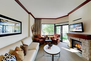 a living room with a couch and a fireplace at Resort at Squaw Creek's 126 & 128 in Olympic Valley