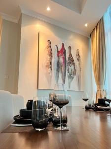 Fairview Luxury Apartments في دار السلام: غرفة طعام مع طاولة مع كؤوس للنبيذ