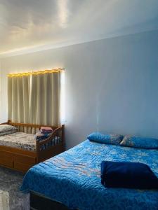1 dormitorio con 2 camas y ventana en Suites Moreninha, en Río de Janeiro