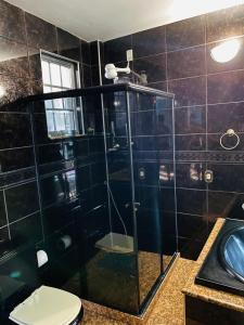y baño con aseo y ducha acristalada. en Suites Moreninha, en Río de Janeiro
