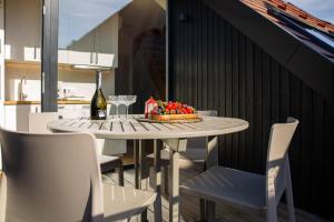 a table with a cake and a bottle of wine at Laikas atostogoms in Juodkrantė