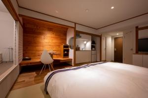 a bedroom with a bed and a desk and a chair at Kawamotoya in Nozawa Onsen