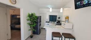 cocina con nevera negra y 2 taburetes en GATED AND VERY SECURED WHITE HOUSE 6 MINS FROM THE BEACH, en Puerto Peñasco