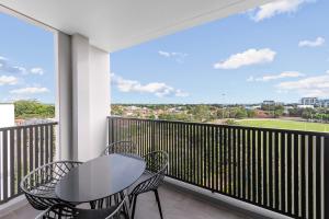a balcony with a table and chairs and a view at Meriton Suites Coward Street, Mascot in Sydney