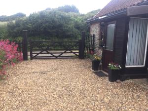 a gate to a garden with flowers and a house at The Annex Rocket cottage in Sidestrand