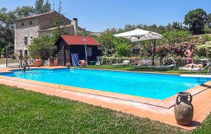 a swimming pool in a yard with an umbrella at Cozy Home In Fragneto Monforte With House A Panoramic View in Fragneto Monforte