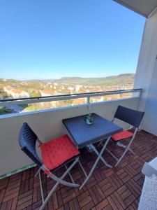 a table and chairs on a balcony with a view at Modernes 2-Zimmer-Apartment mit Balkon und Netflix in Jena