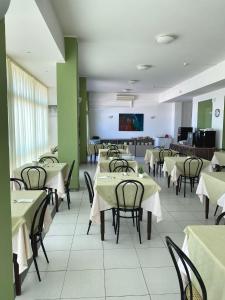 a dining room with tables and chairs and a tv at HOTEL FLYING in Pesaro