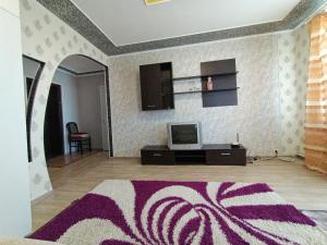 - un salon avec une télévision et un tapis violet dans l'établissement Гагарина 9, à Kropyvnytsky