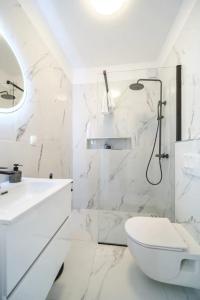 a white bathroom with a shower and a toilet at Apartment Vin - sea promenade in Supetar
