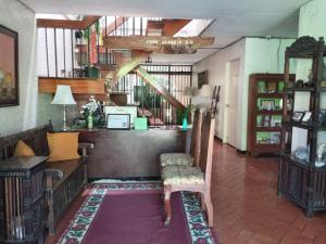 a living room with a chair and a staircase at Casa Joaquin BnB in Manila