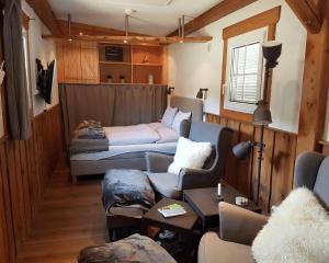 uma sala de estar com uma cama e um sofá em Living Legends - Tiny House auf den Wiesen der Edermühle em Grosspertholz