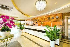 Happy Life Hotel District 7 Gần SECC في مدينة هوشي منه: مطعم يوجد به كونتر وزهور في اللوبي