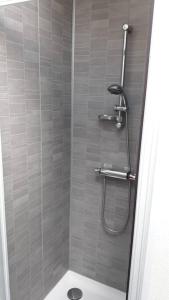 une salle de bain avec douche et toilettes dans l'établissement La p'tite maison de la plage, à Fermanville