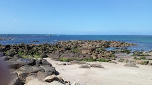 une plage rocheuse avec l'océan en arrière-plan dans l'établissement La p'tite maison de la plage, à Fermanville 9 autres photos